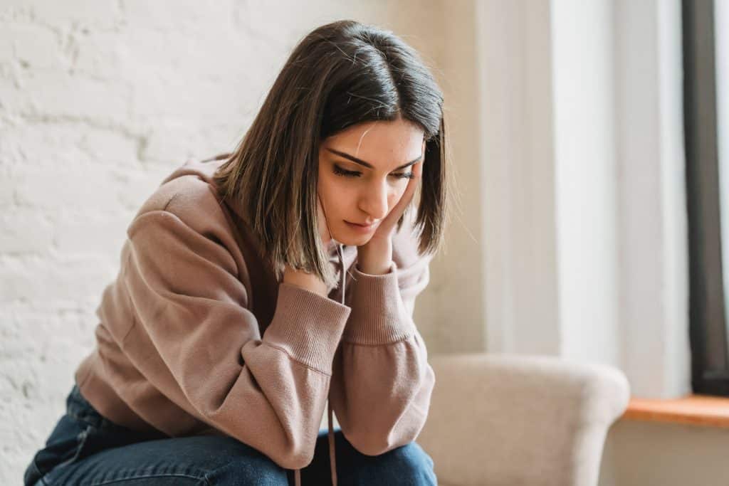 Fatigué à la jeune femme assise sur le canapé.