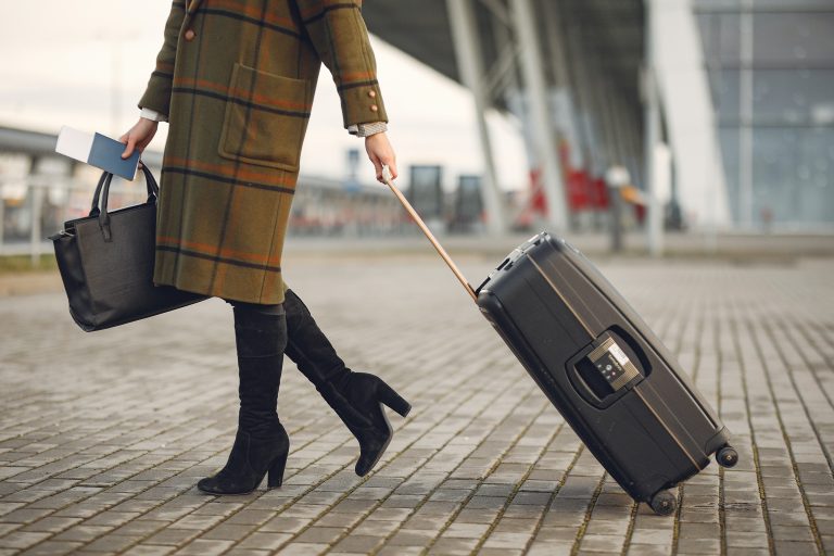 Femme à la mode portant son sac à l'aéroport.